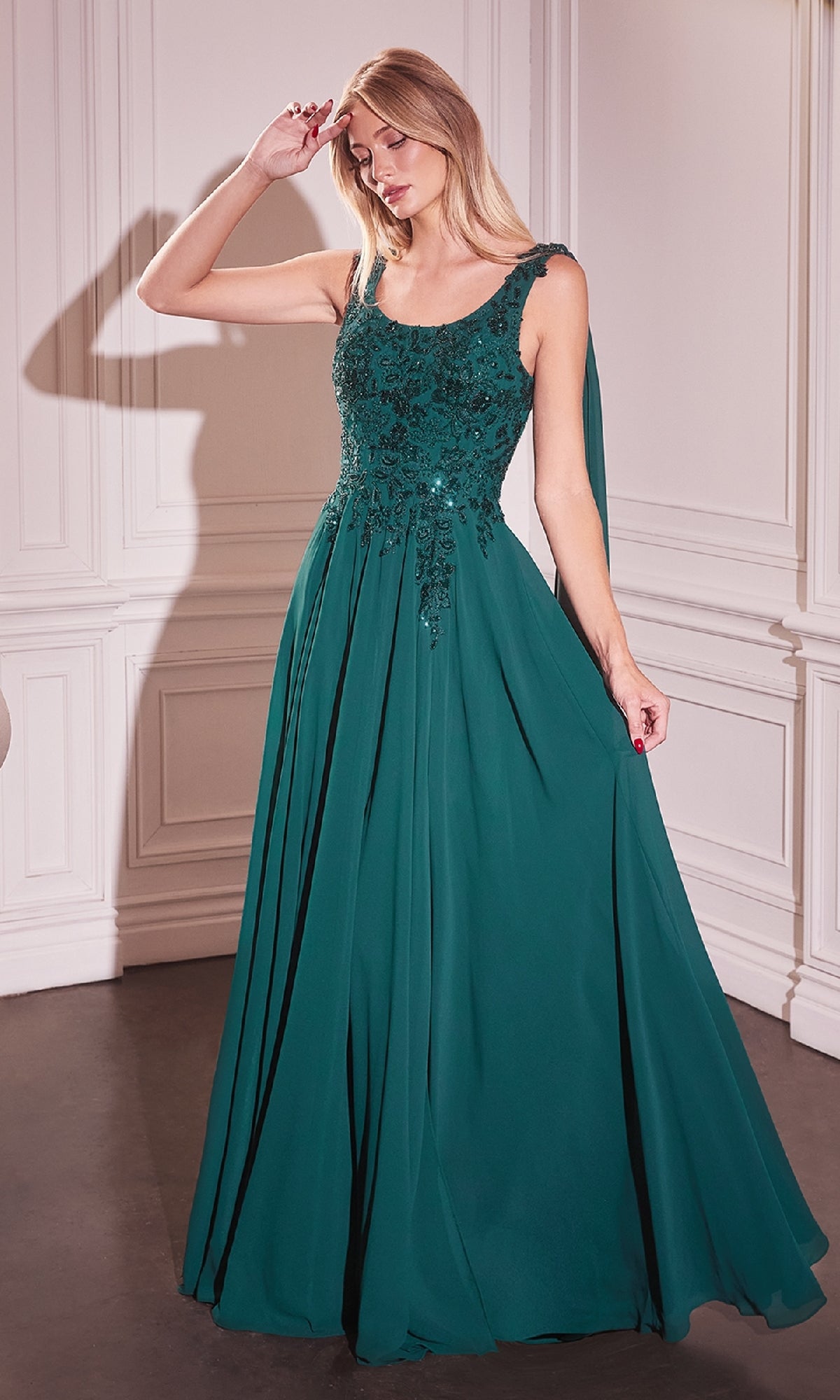 A woman wearing the Ladivine CDS509 Shoulder Sash Long Formal Dress with a fitted, embellished bodice stands in a well-lit room with white paneled walls.